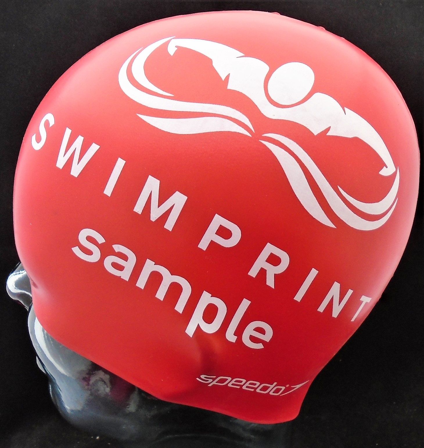 Eine rote Badekappe mit der Aufschrift „Swimprint Sample“