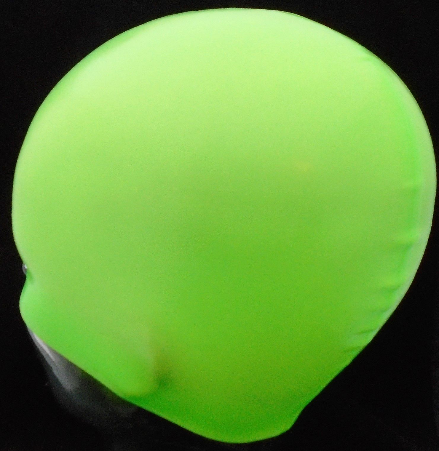 Ein grüner Ball liegt auf einer schwarzen Oberfläche