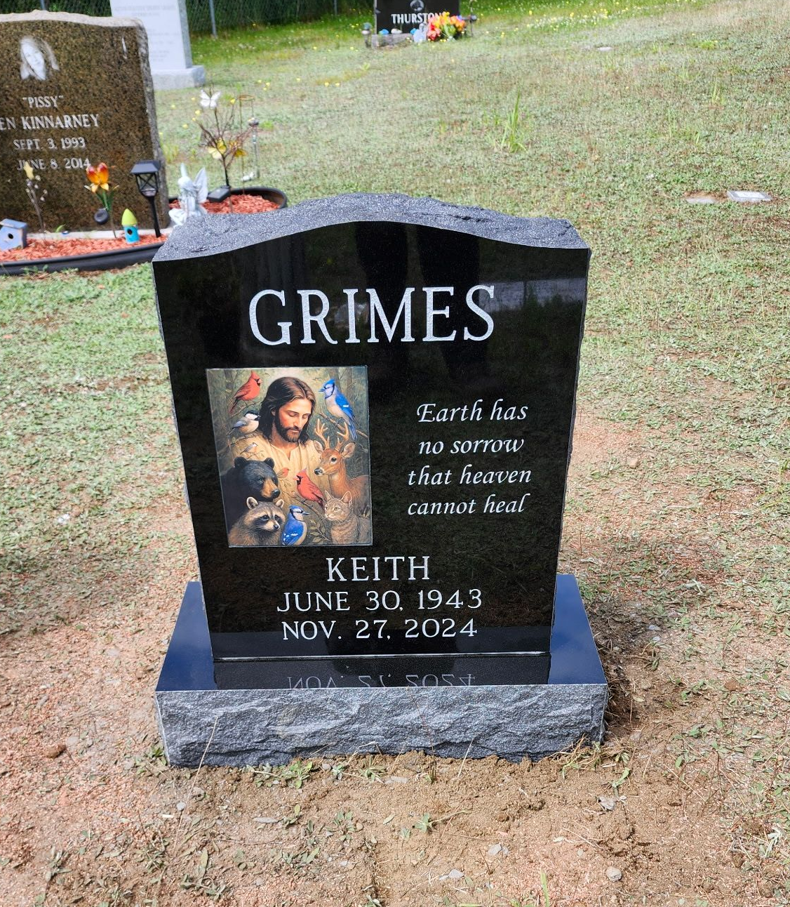Black granite gravestone with “GRIMES” and a photo, set in a grassy cemetery.