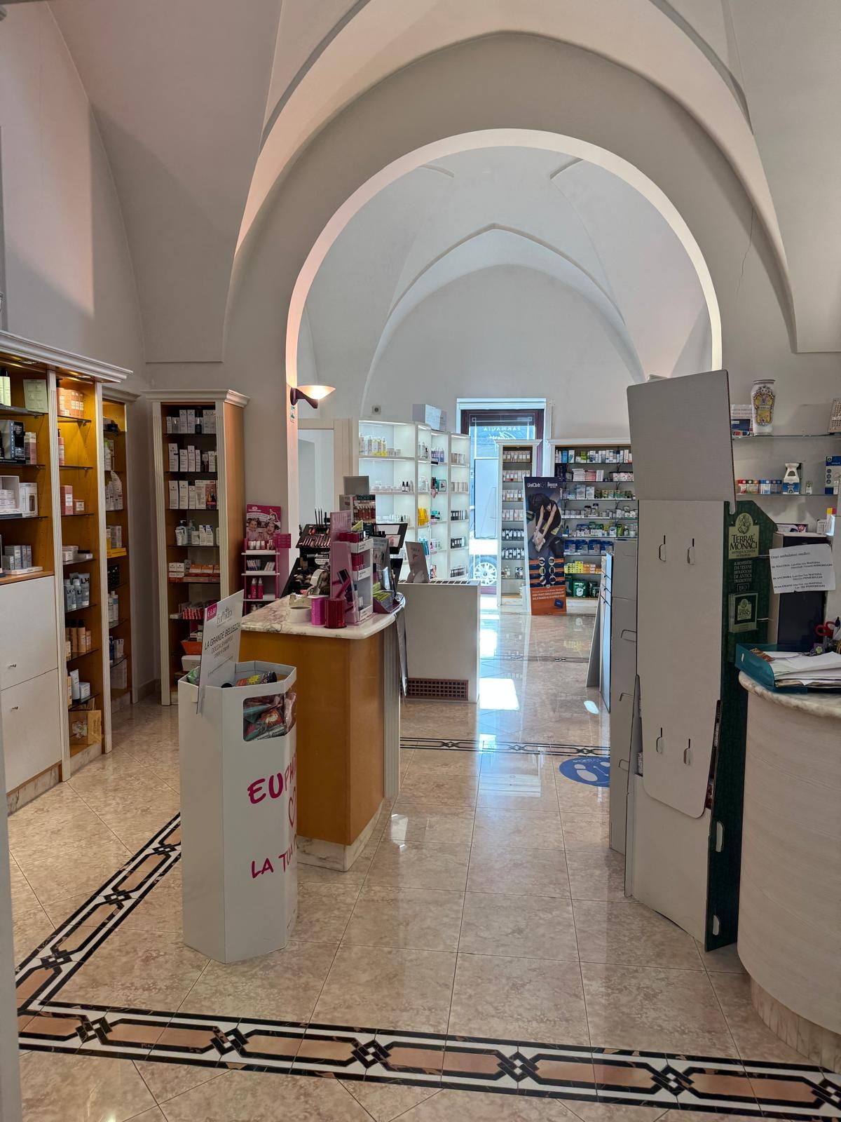 Una farmacia con un cestino bianco con la scritta 