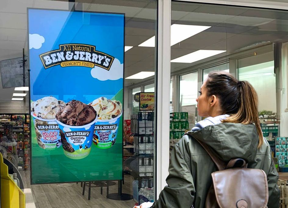 Woman looking at a Ben & Jerry’s ice cream ad display in a store.