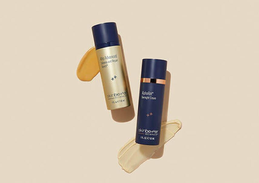 Two bottles of cosmetics are sitting next to each other on a table.