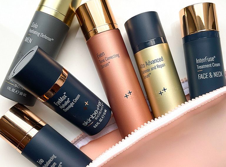 A bunch of bottles of cosmetics are sitting on top of each other on a table.