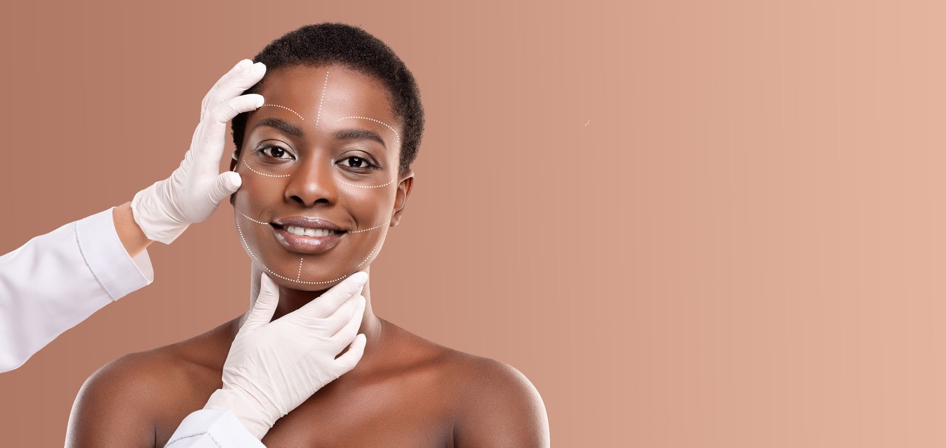Person receiving a facial treatment on a peach background, with hands gently framing the face