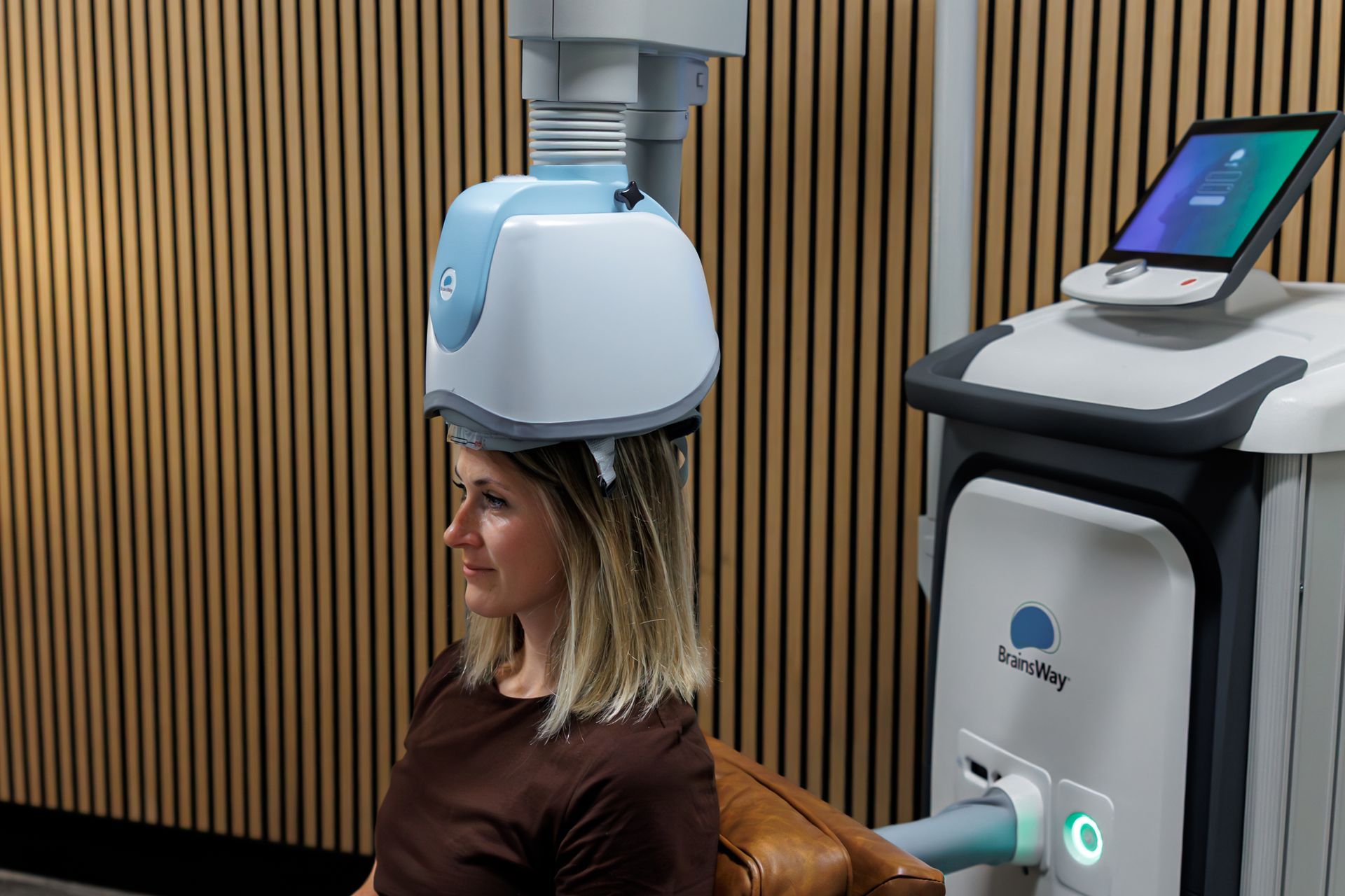 Person wearing a white head-mounted device beside a medical machine in a modern clinic