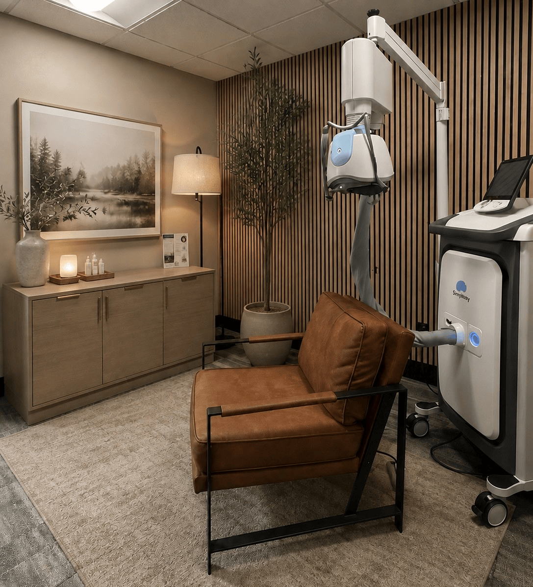 Cozy medical treatment room with recliner chair, IV stand, cabinet, lamp, and wall art