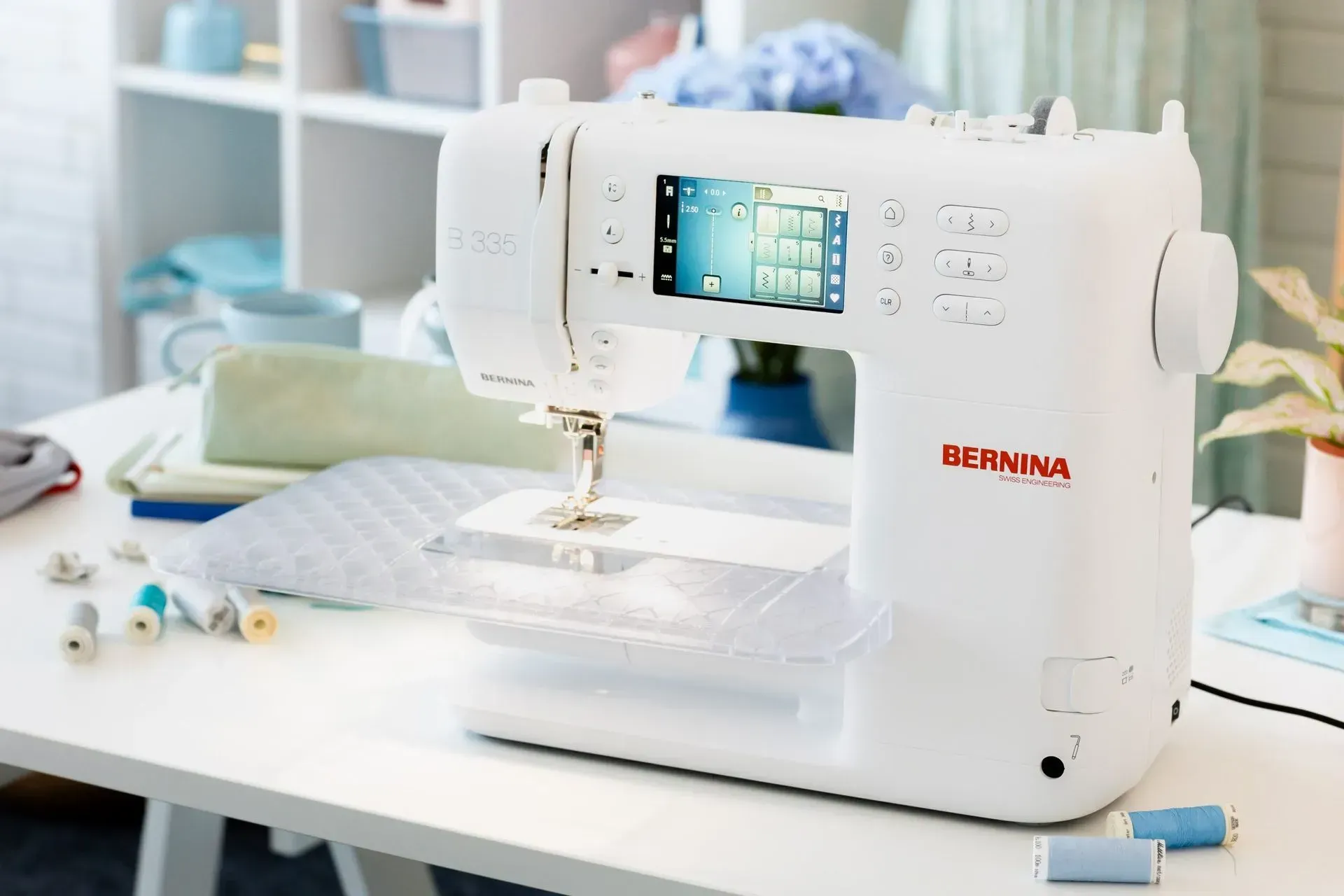 White sewing machine on a bright desk with fabric, scissors, and sewing supplies