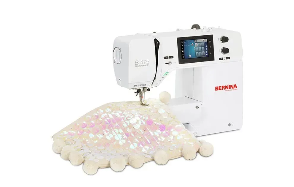 Industrial embroidery machine stitching a pastel sequin fabric design