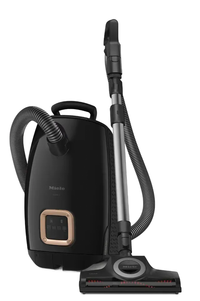Black canister vacuum cleaner with hose and floor head on white background