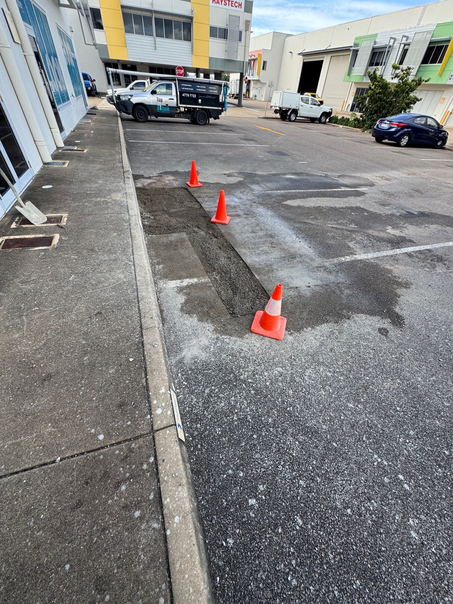 A Hole in The Ground with A Yellow Caution Sign in The Background — Top To Bottom Plumbing in Garbutt, QLD