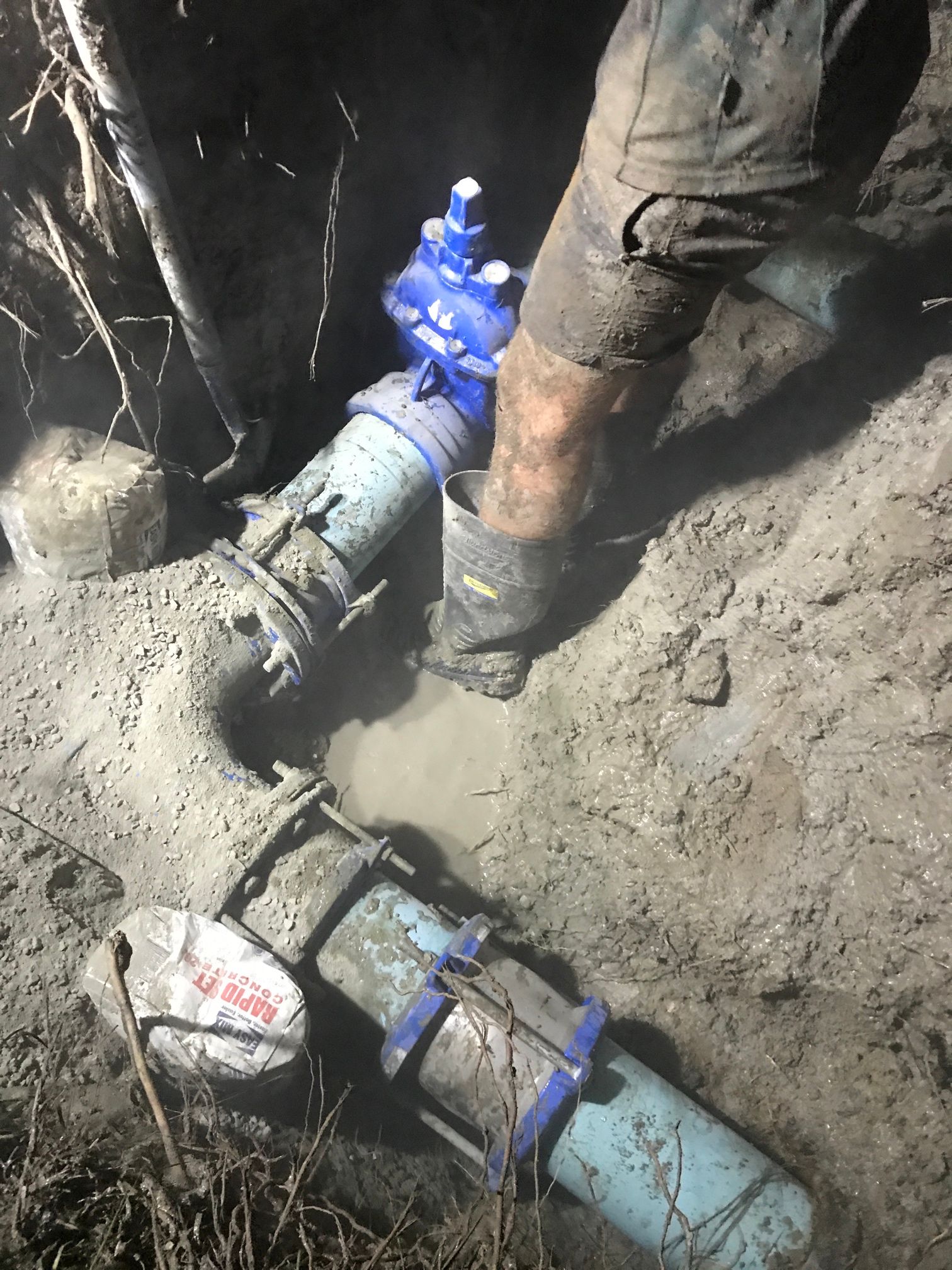A Person Is Fixing a Faucet that Is Leaking Water — Top To Bottom Plumbing in Garbutt, QLD