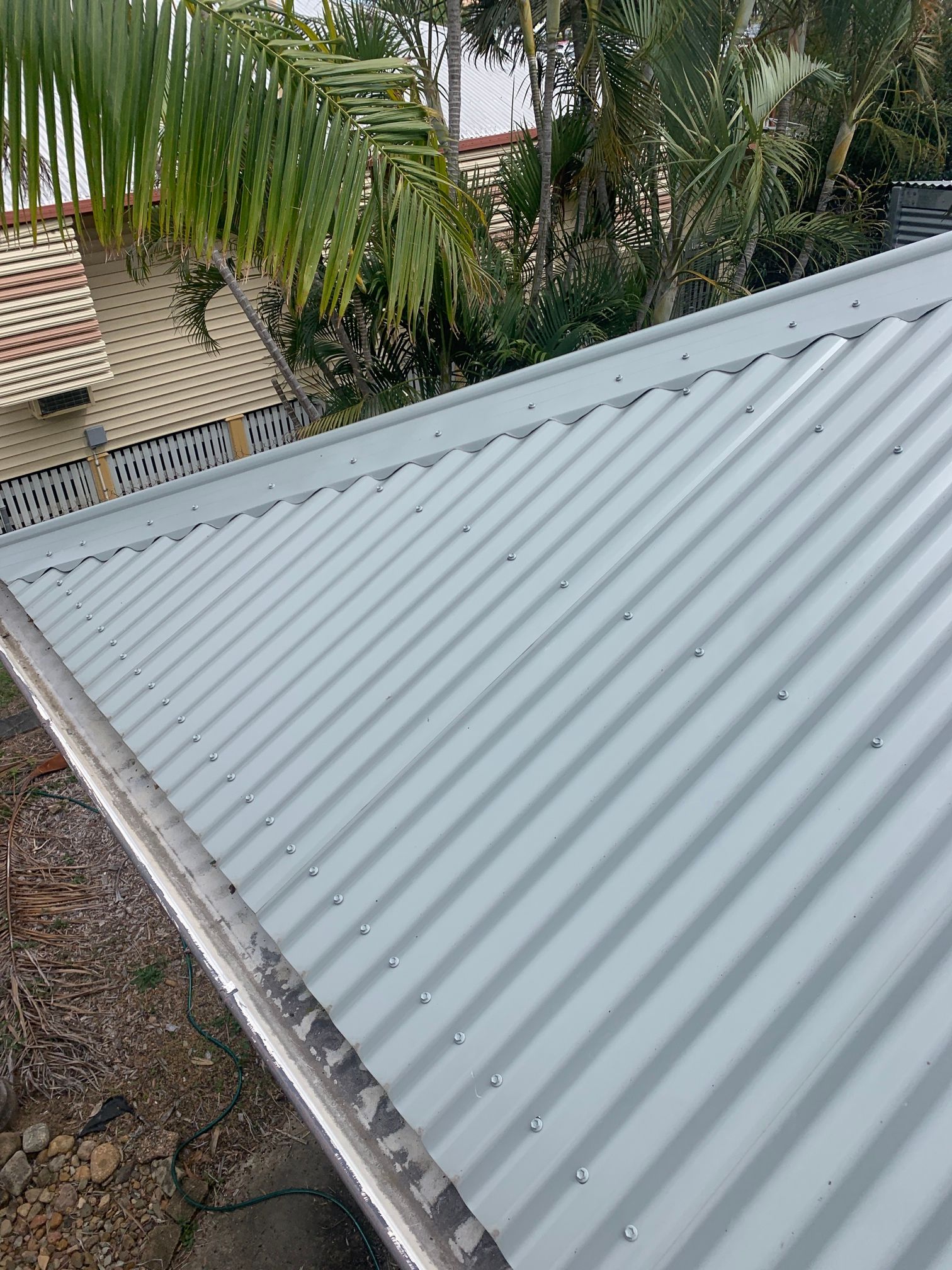 A Close up Of a Metal Roof with A Blue Sky in The Background — Top To Bottom Plumbing in Garbutt, QLD