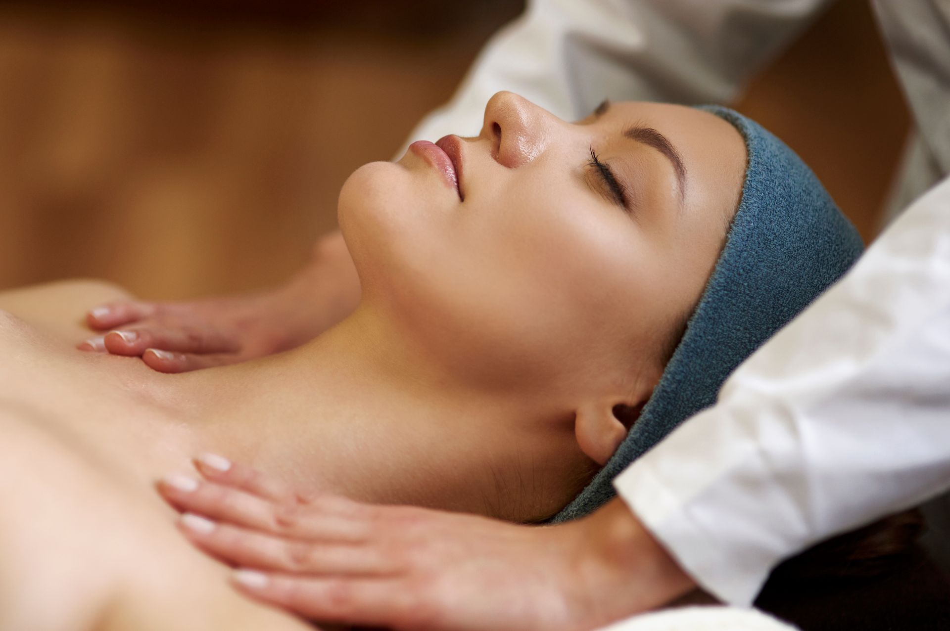 A person receives a relaxing neck and shoulder massage from a professional therapist in a spa setting.