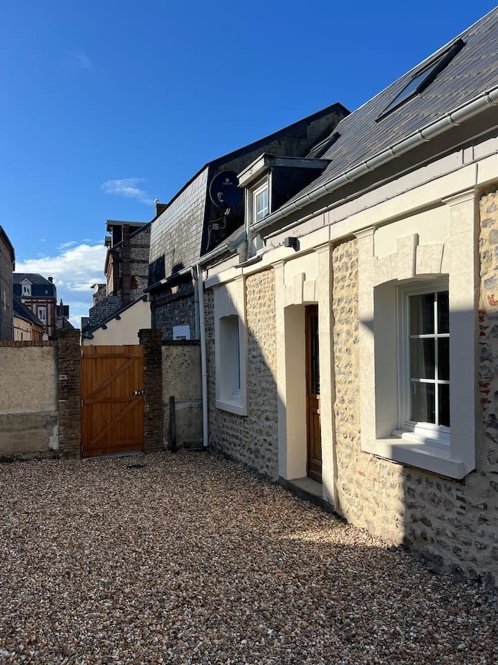Cour intérieure avec sol en gravier et bâtiments en pierre sous un ciel d'un bleu éclatant