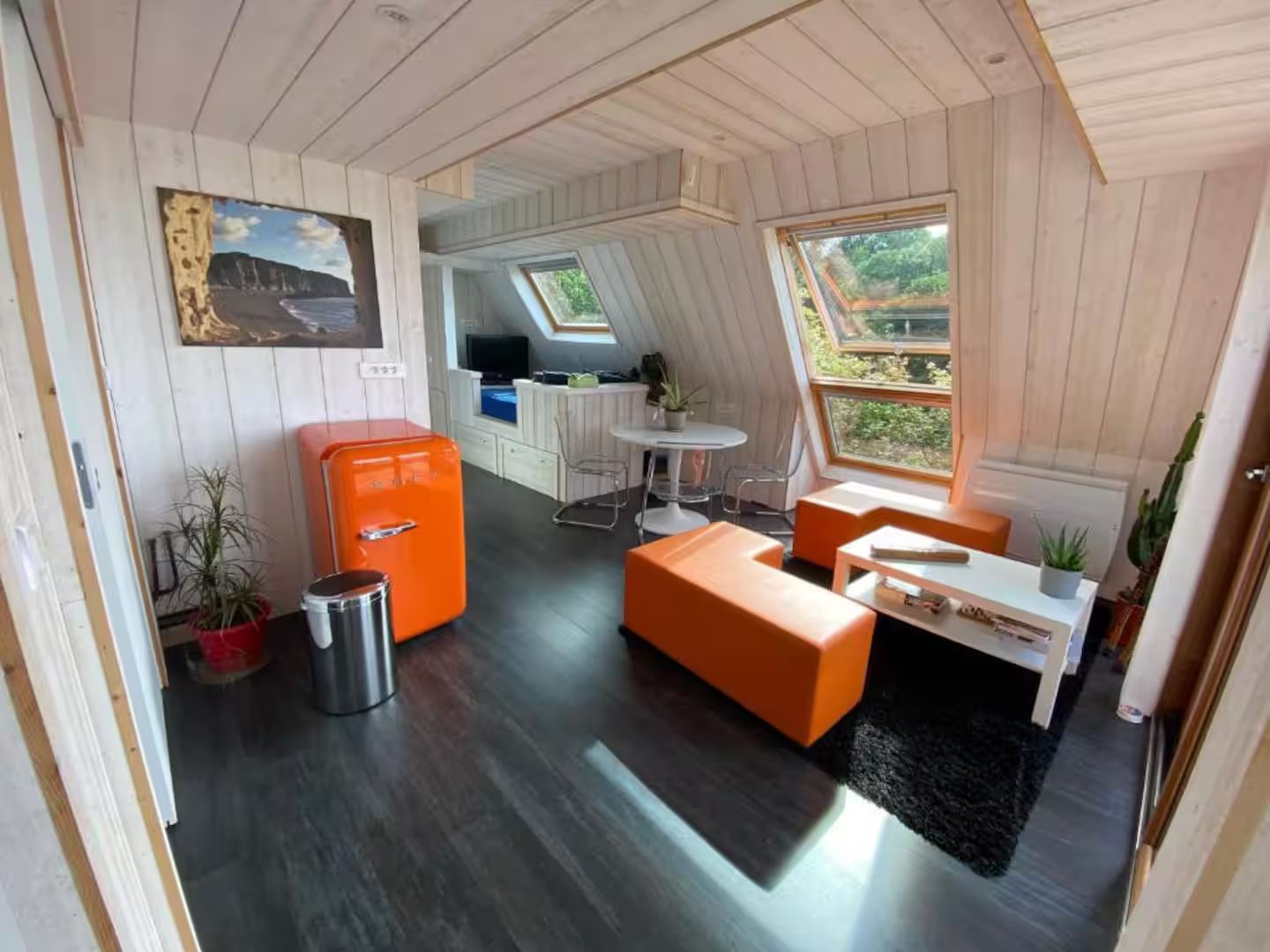 Un salon avec des meubles orange et un réfrigérateur orange