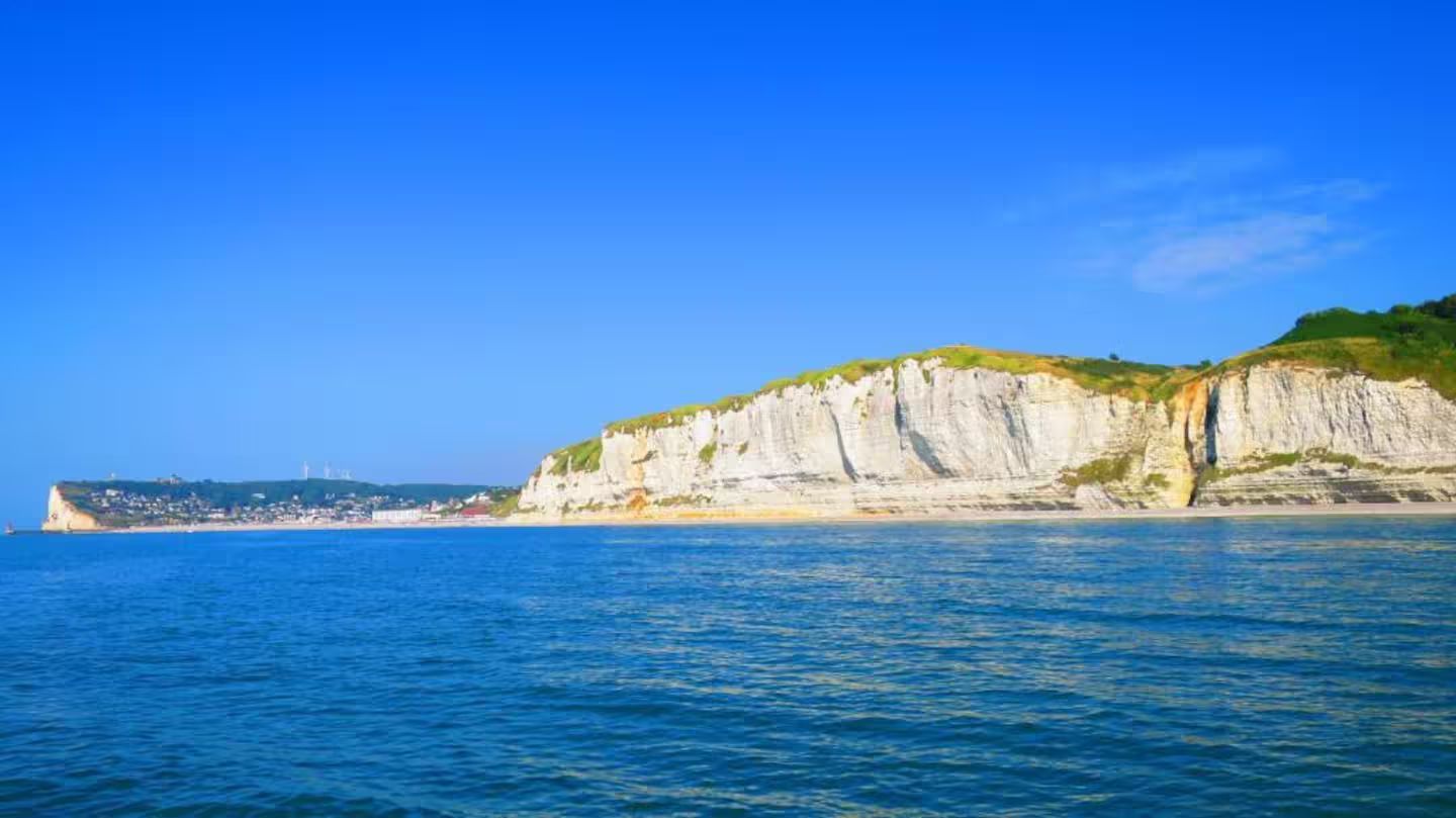 Une grande étendue d'eau avec une falaise en arrière-plan.