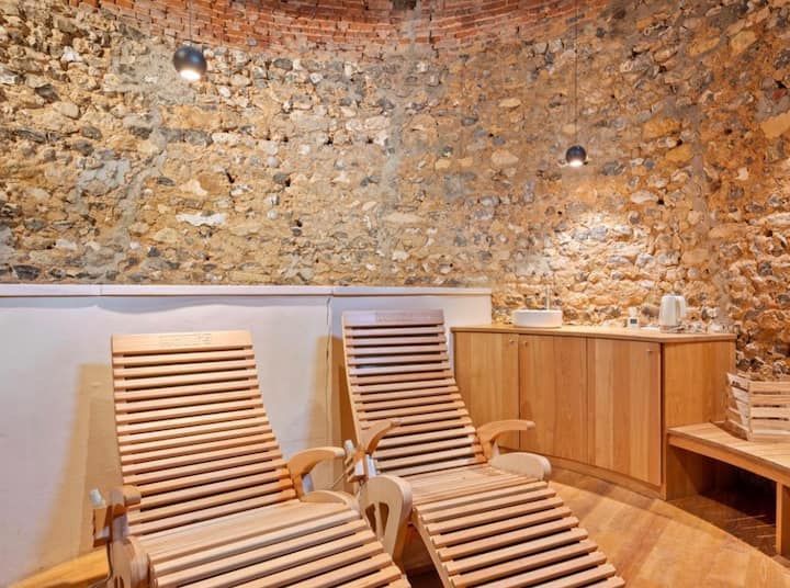 Deux fauteuils en bois dans une salle de détente rustique aux murs en pierre