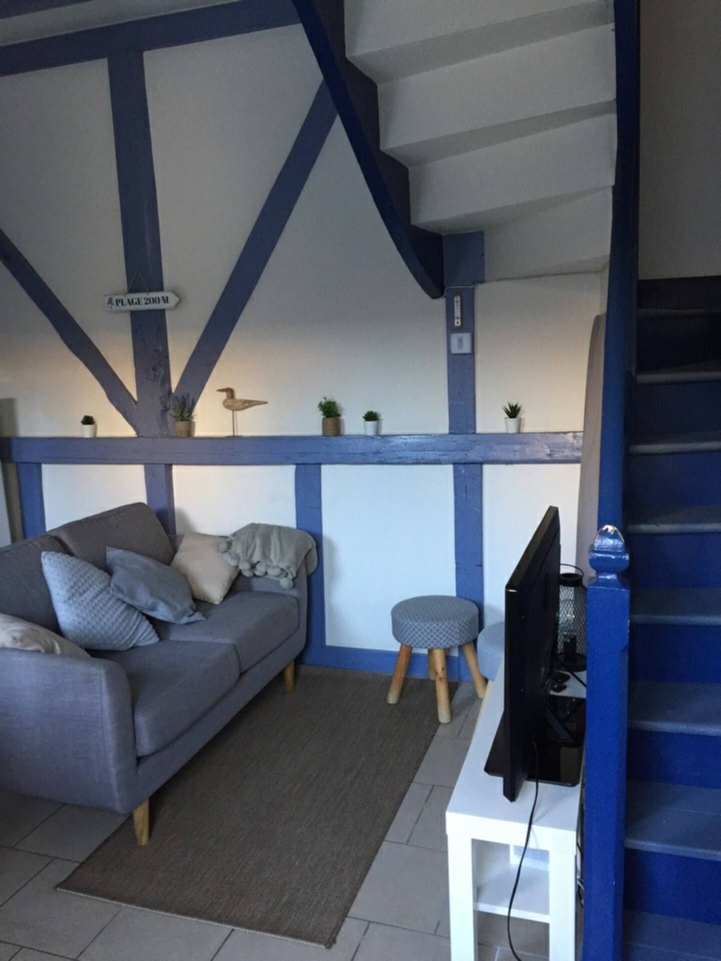 Autre vue du salon du gite avec un canapé et une télé