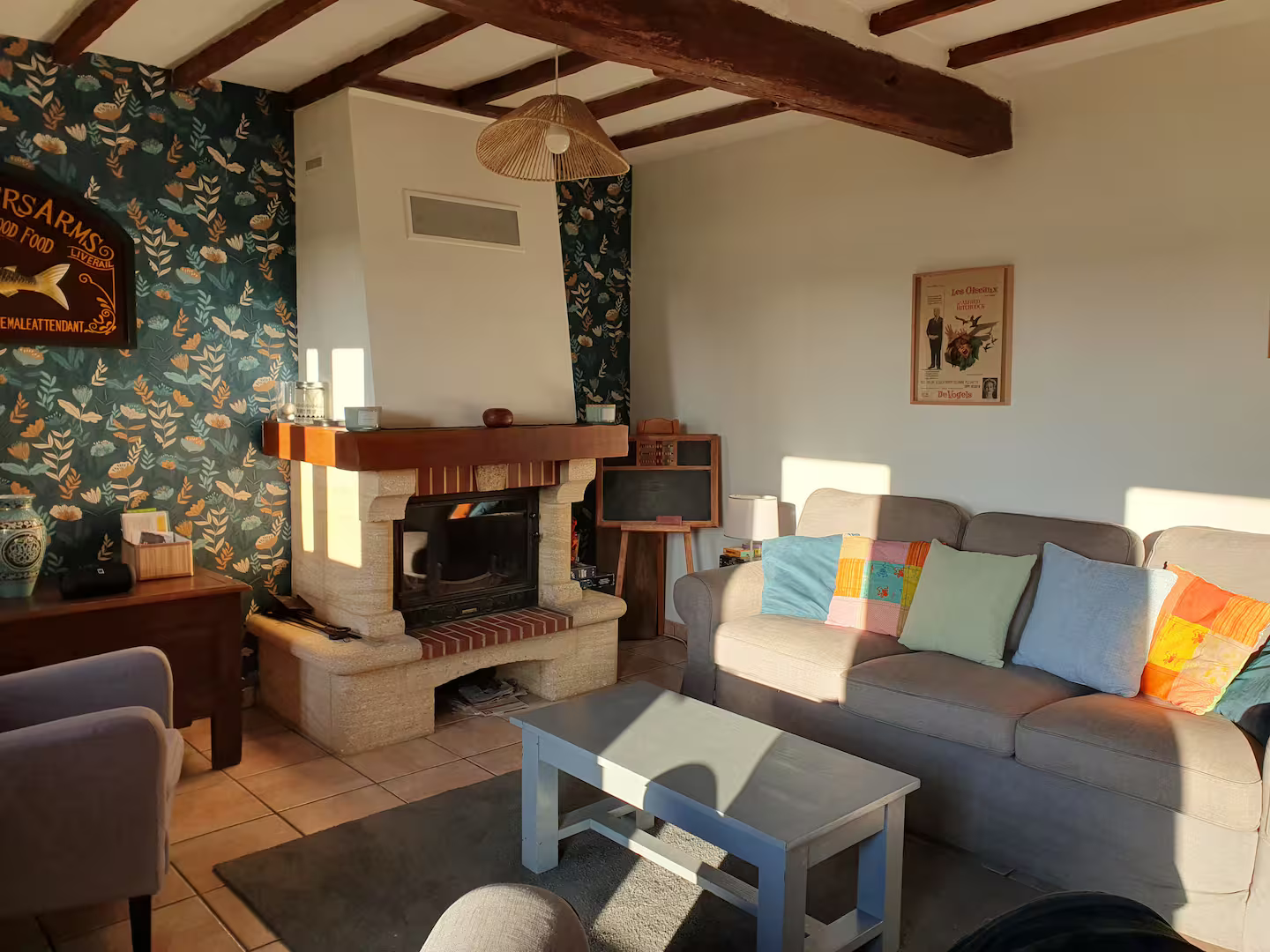 Un salon avec un canapé, des chaises, une table basse et une cheminée.