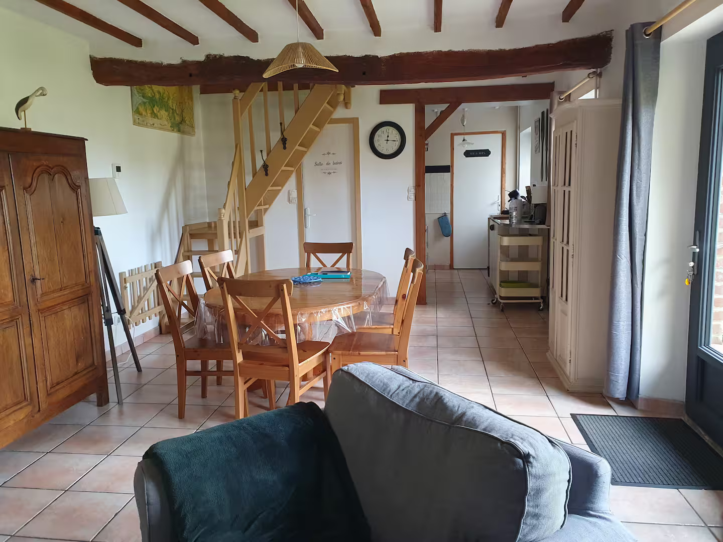 Un salon avec une table et des chaises et un escalier
