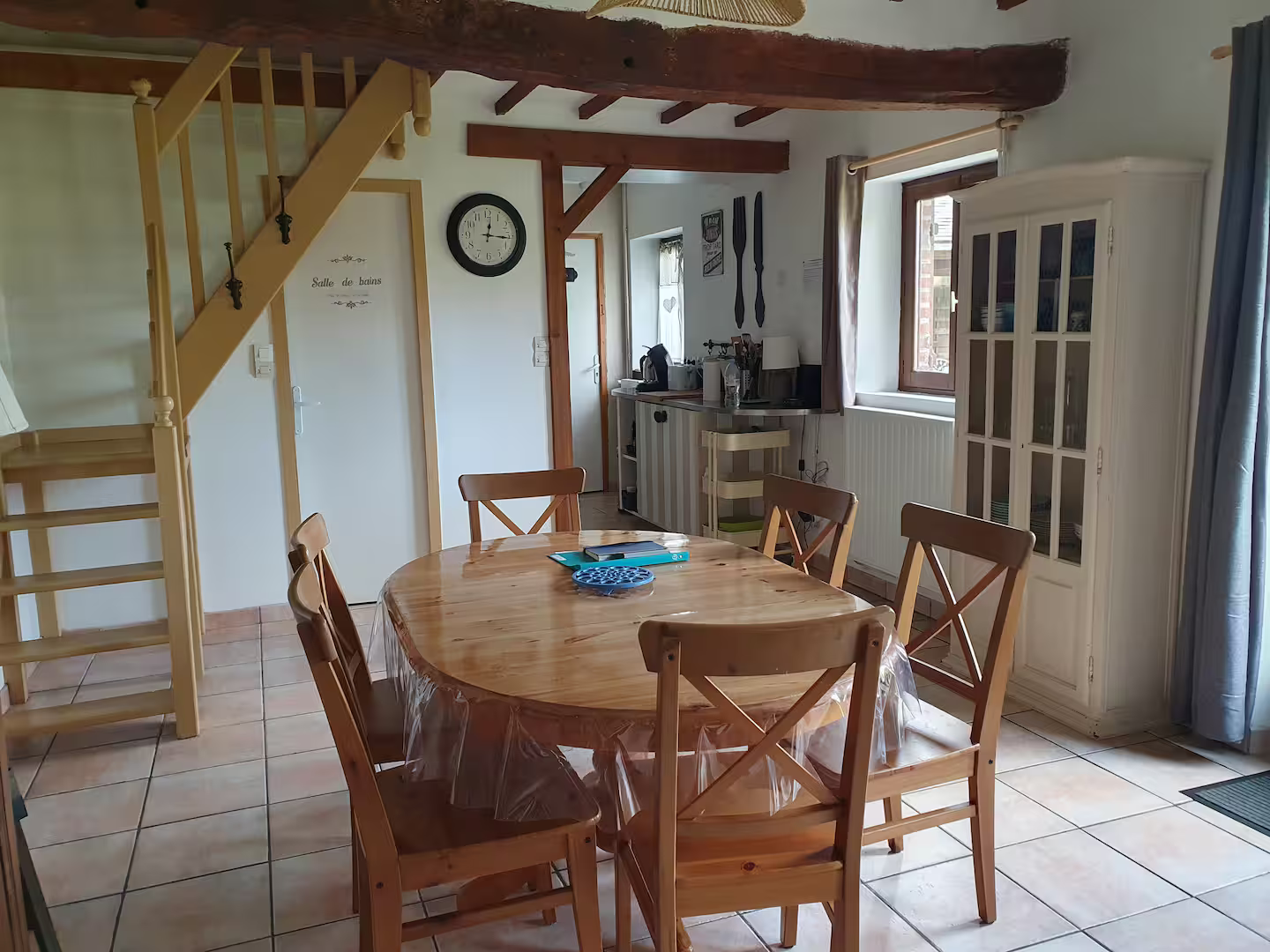 Une salle à manger avec une table et des chaises et une horloge au mur.