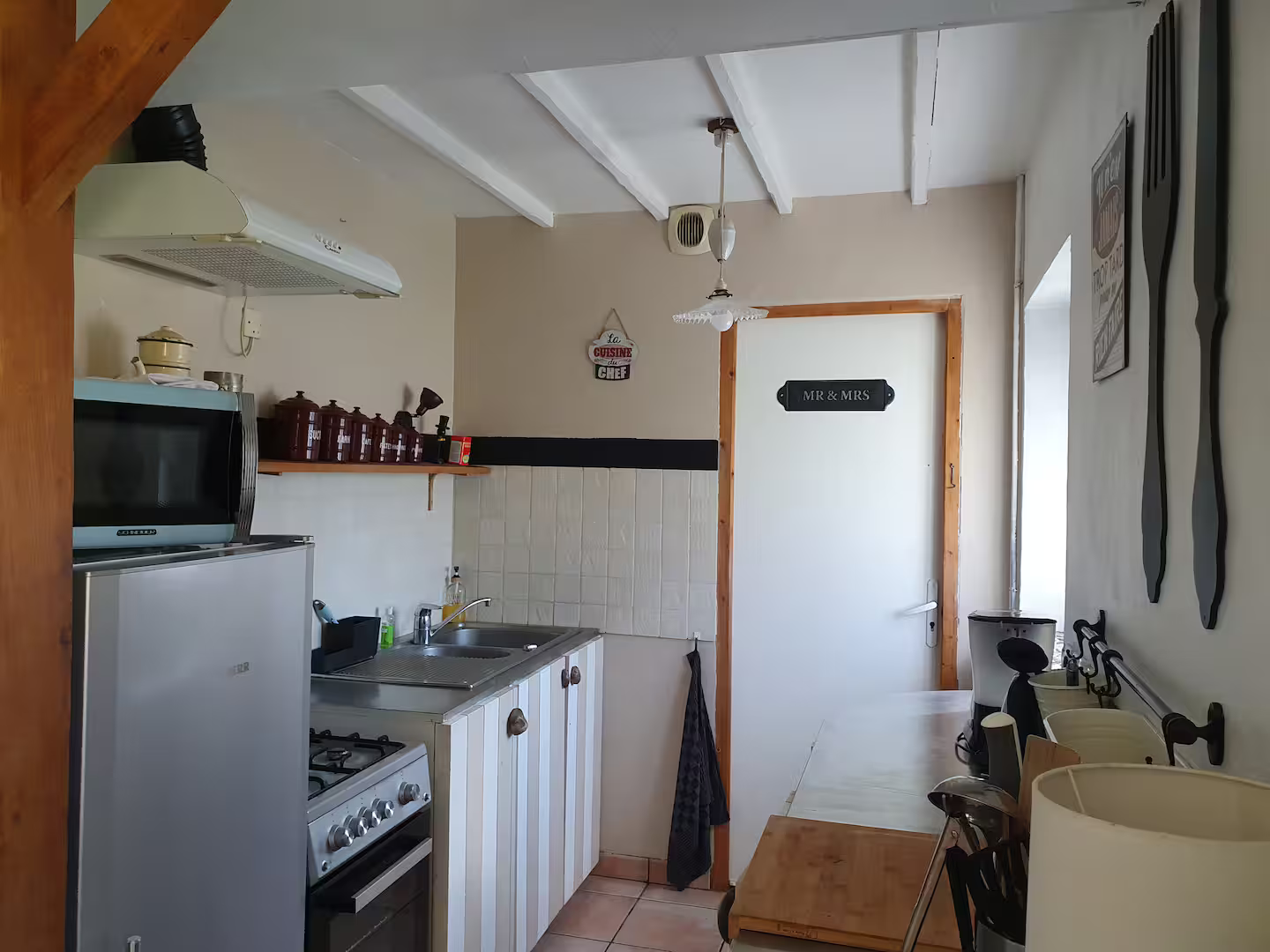 Une cuisine avec une cuisinière, un réfrigérateur et un micro-ondes