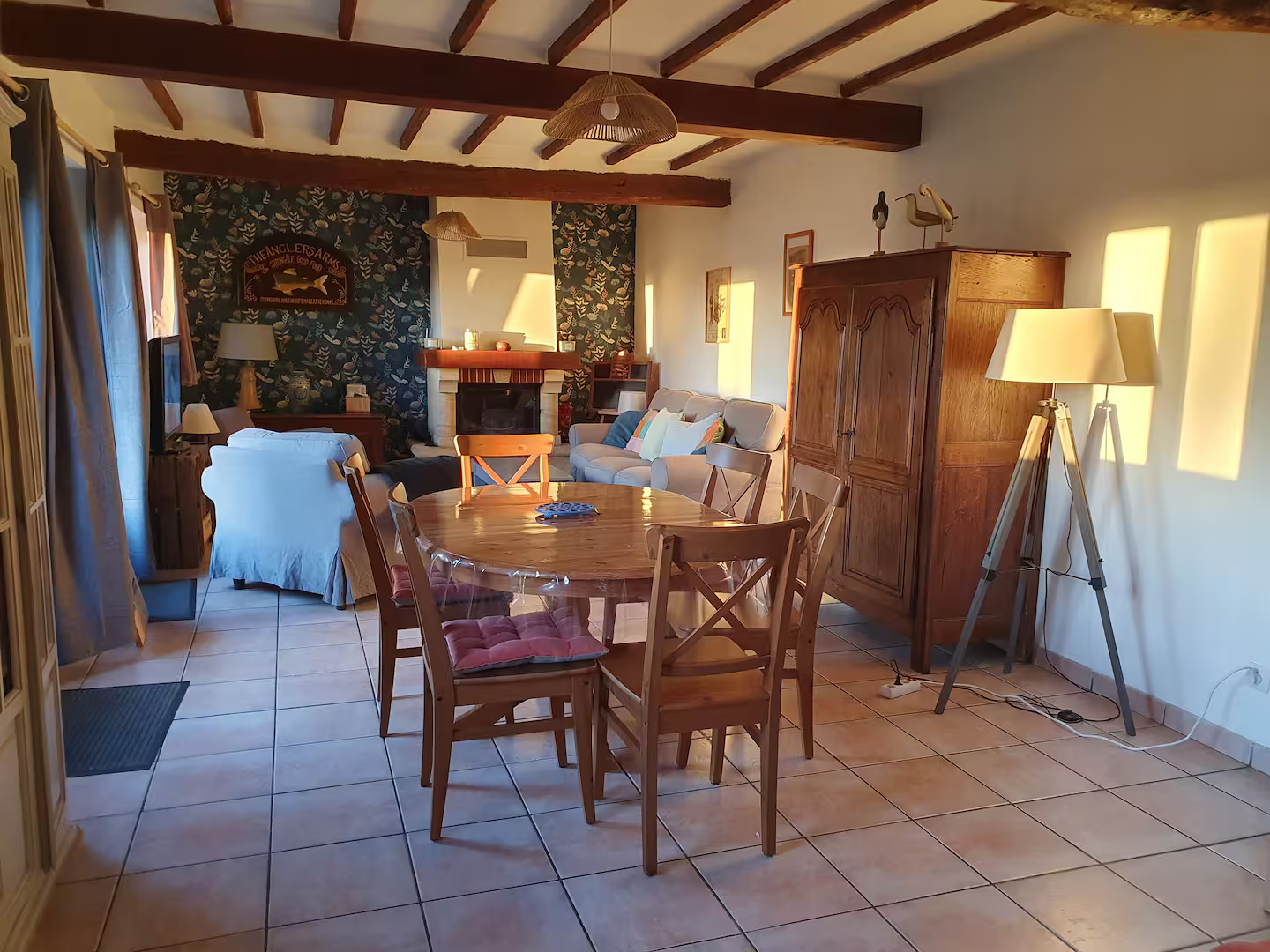 Un salon avec une table et des chaises et une cheminée