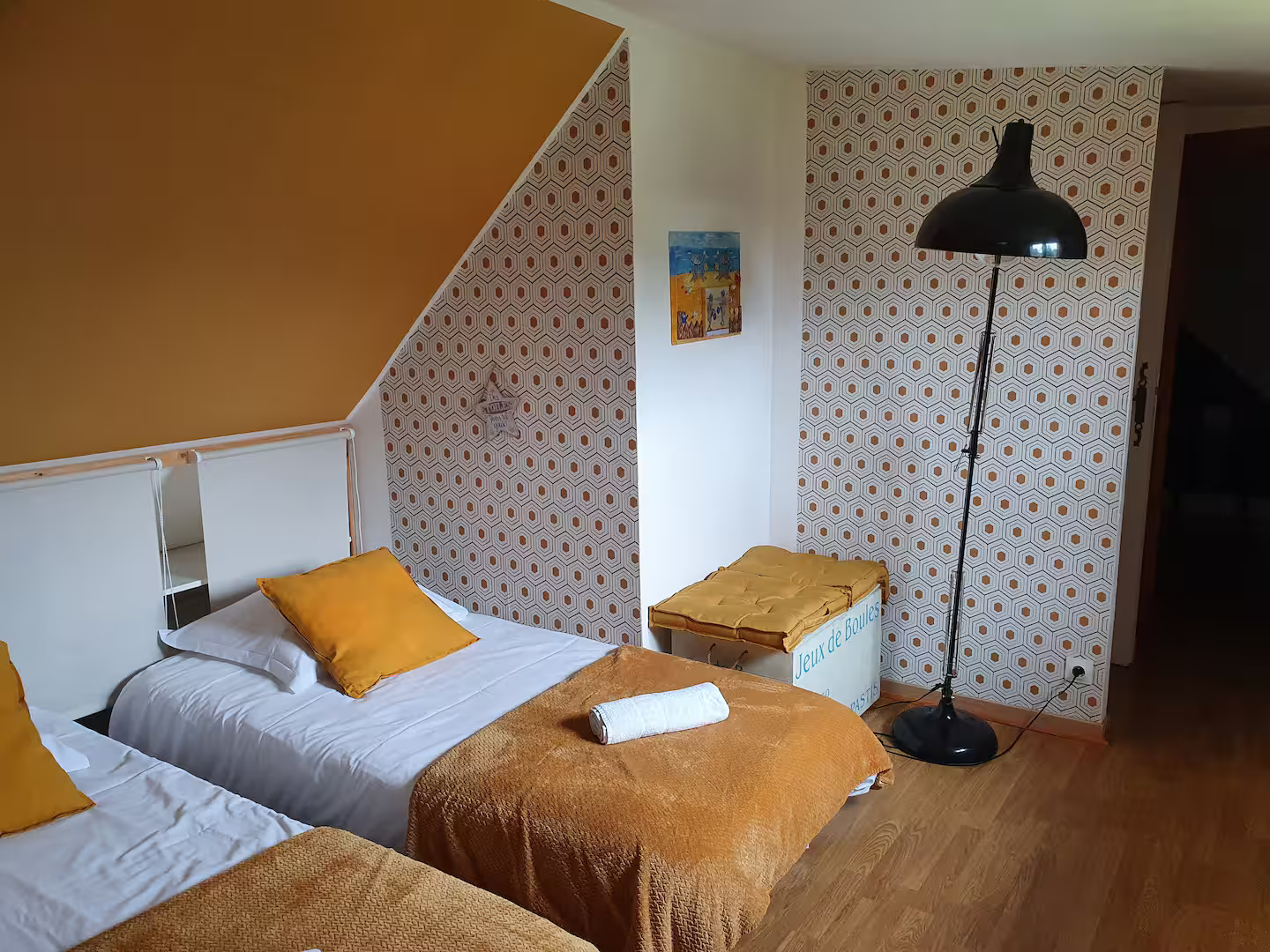 Une chambre avec deux lits et une lampe.