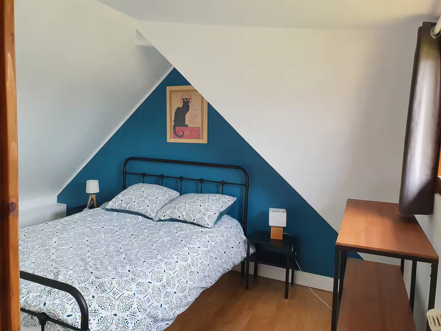 Il y a une photo d'un chat sur le mur au dessus du lit.