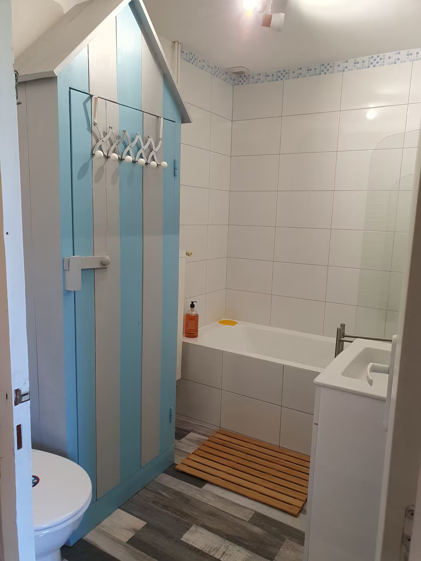 Une salle de bain avec WC, lavabo, baignoire et douche.
