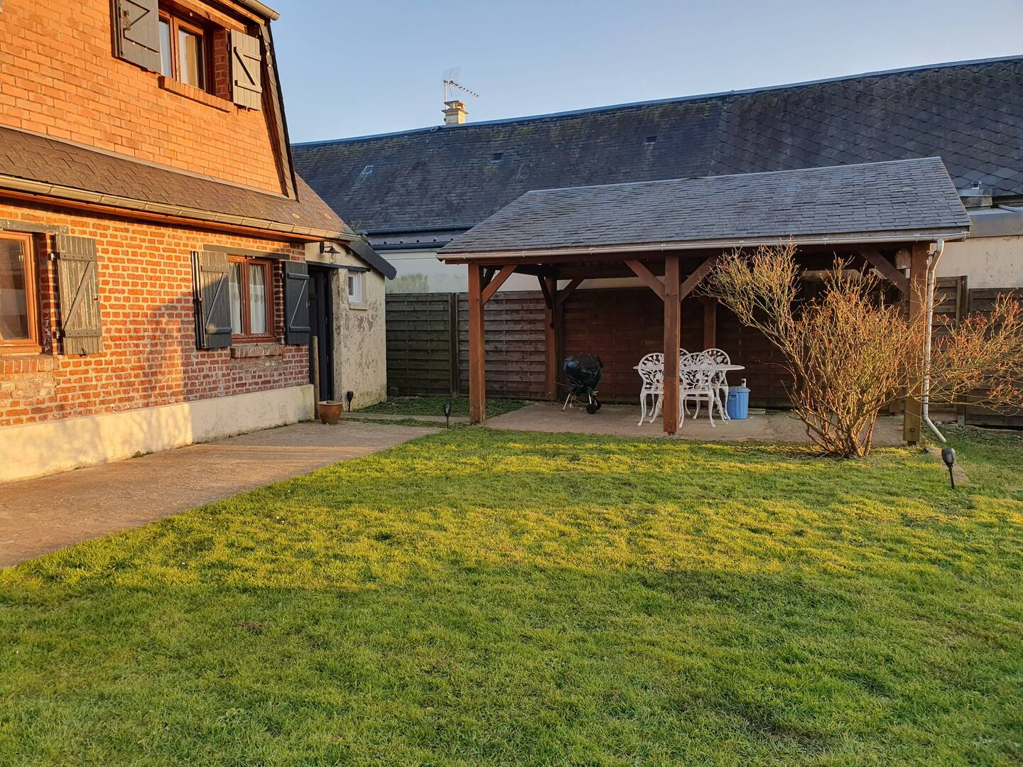 Une maison en briques avec une grande pelouse devant.