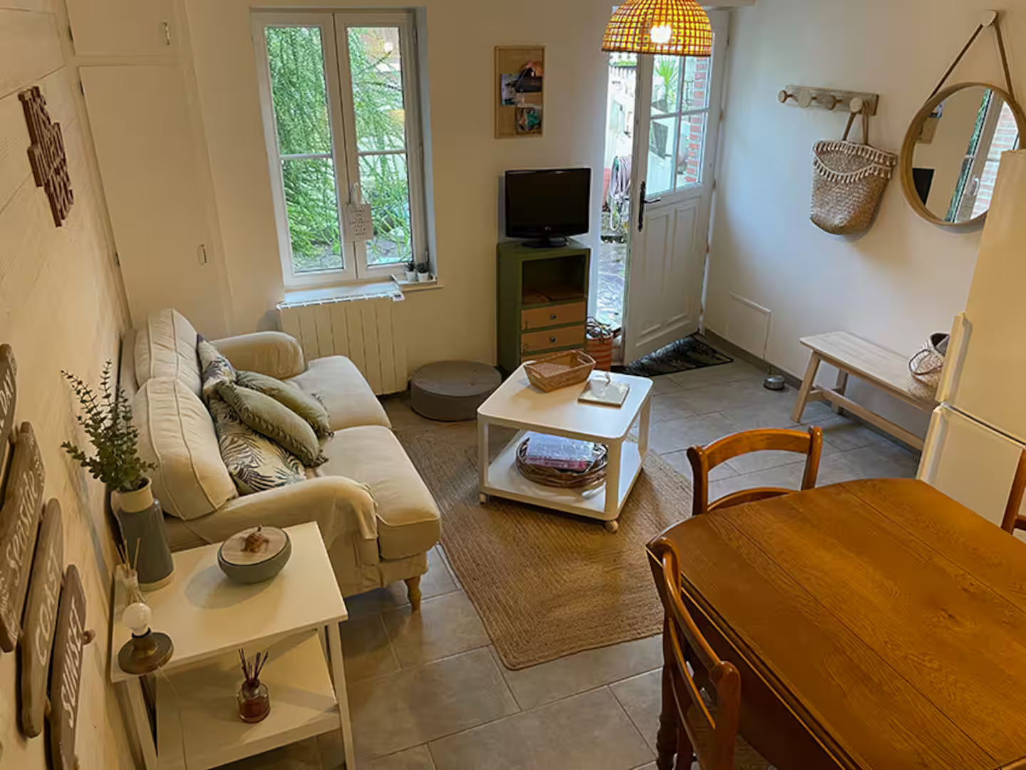 Un salon avec un canapé, une table, des chaises et une télévision.