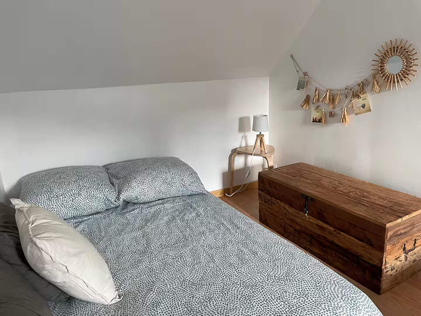 Une chambre avec un lit et un coffre en bois.