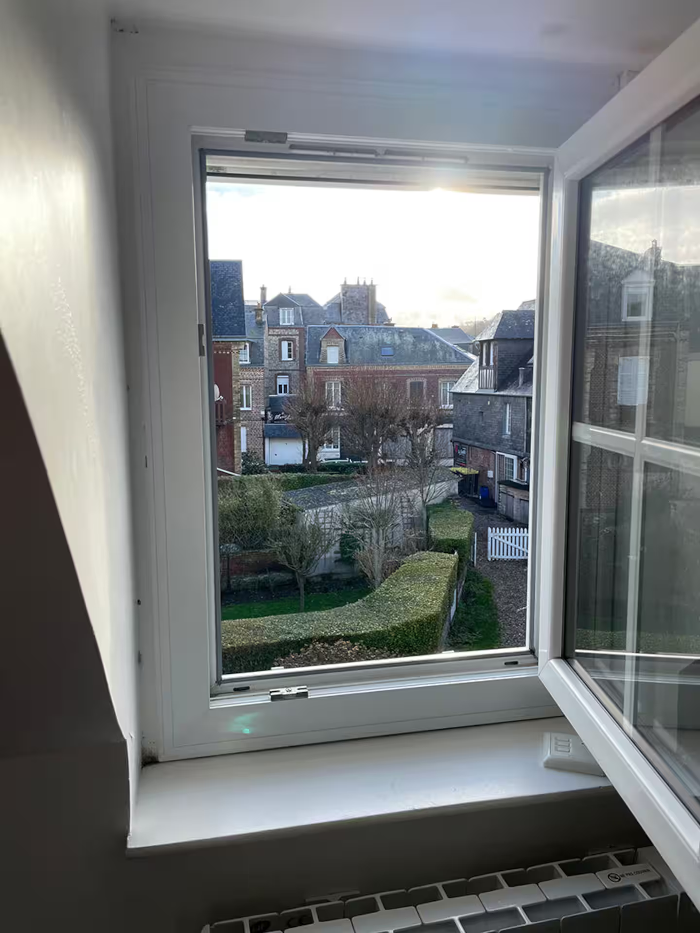 Une fenêtre avec vue sur une ville et des bâtiments.