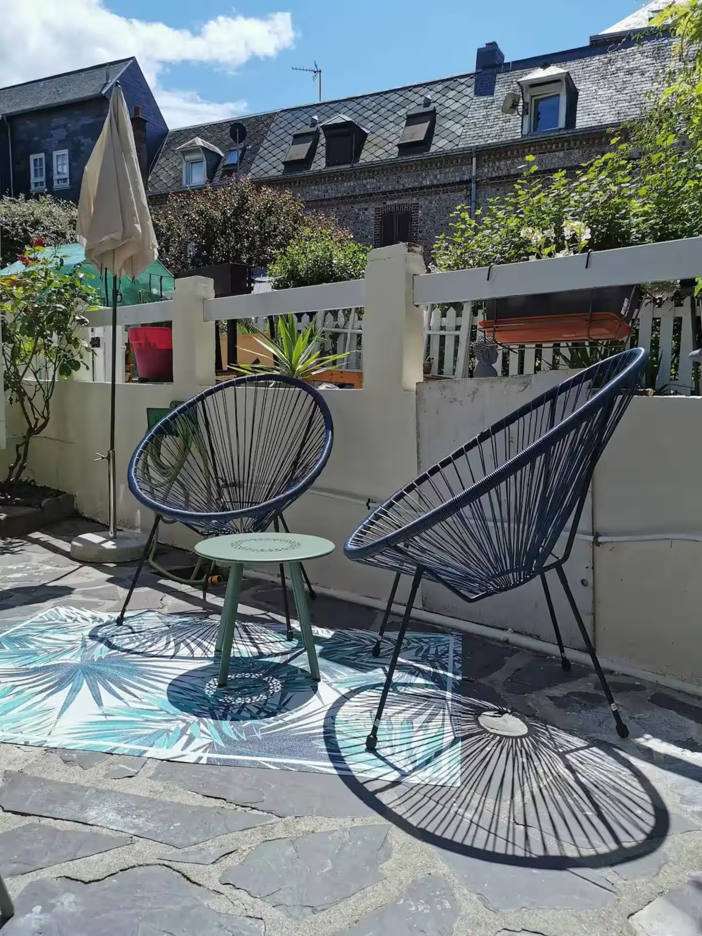 Il y a deux chaises et une table sur le patio.