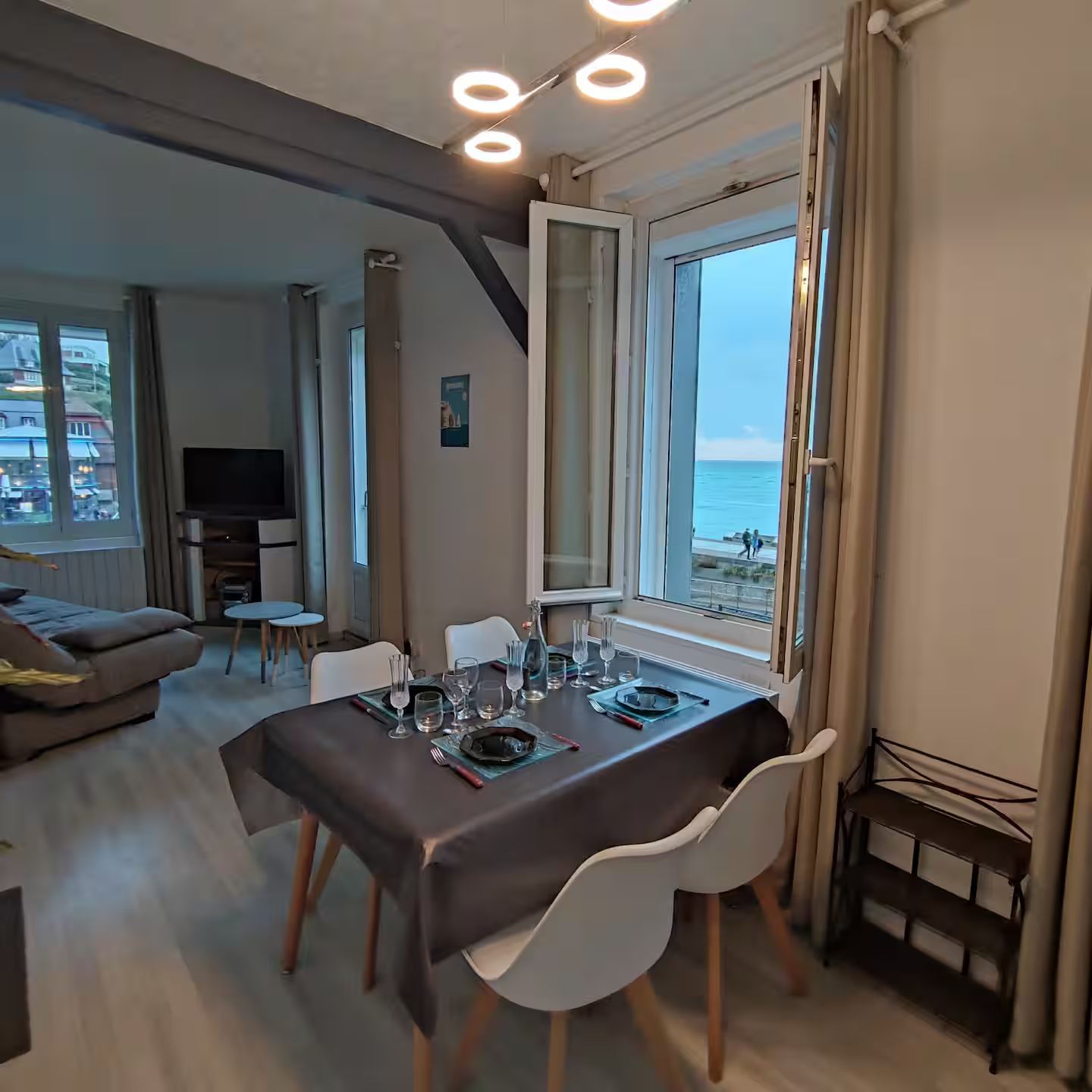 Une salle Ă manger avec une table et des chaises et une fenĂȘtre donnant sur l'ocĂ©an
