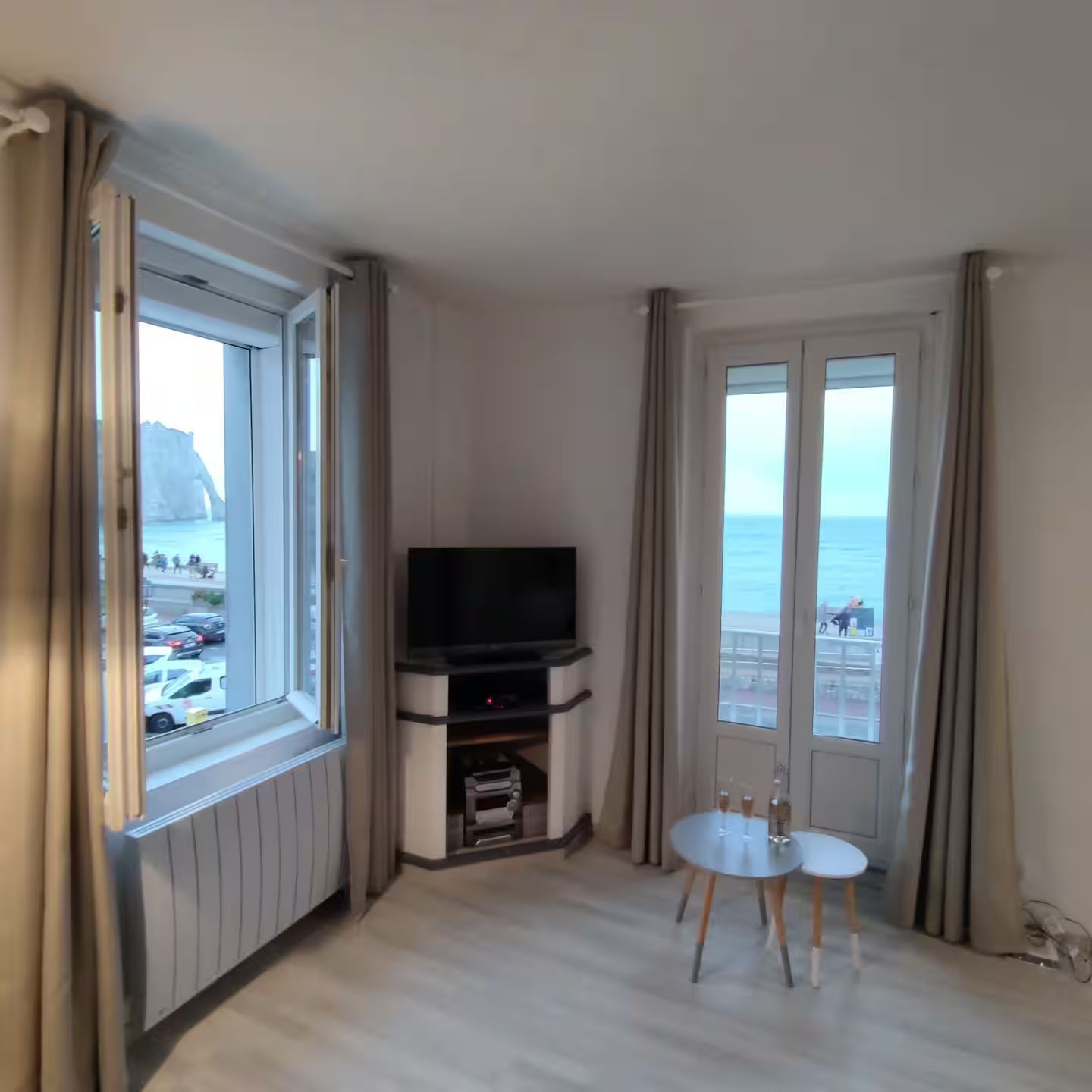 Un salon avec une télévision à écran plat et une vue sur l'océan