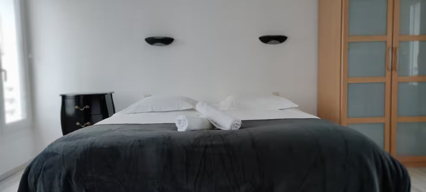 Une chambre avec un grand lit et une armoire.