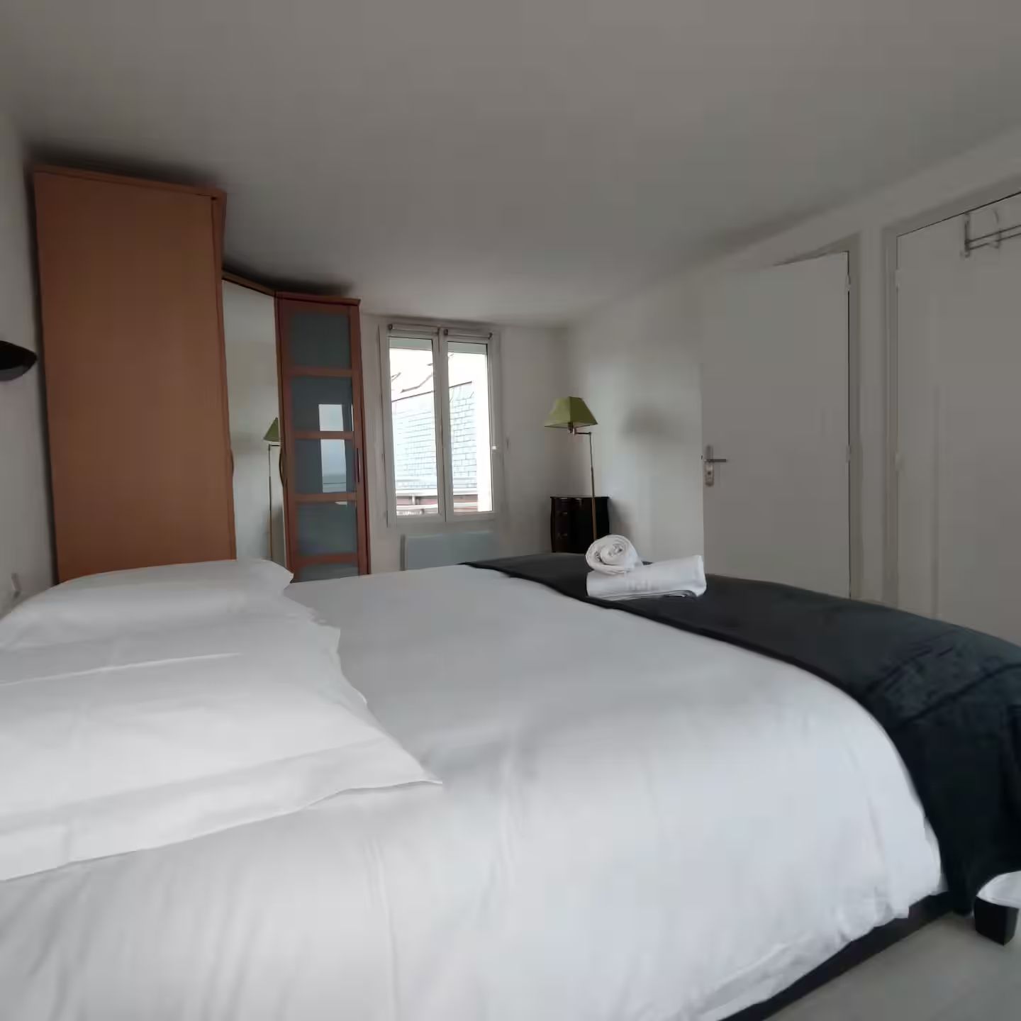 Une chambre avec un grand lit et une fenĂȘtre