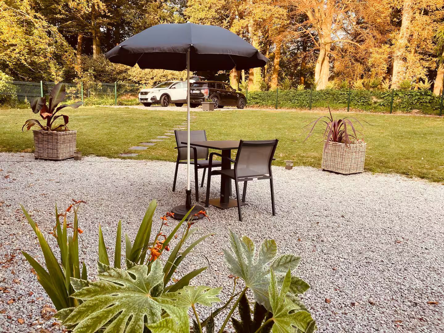 Un patio avec une table et des chaises sous un parasol