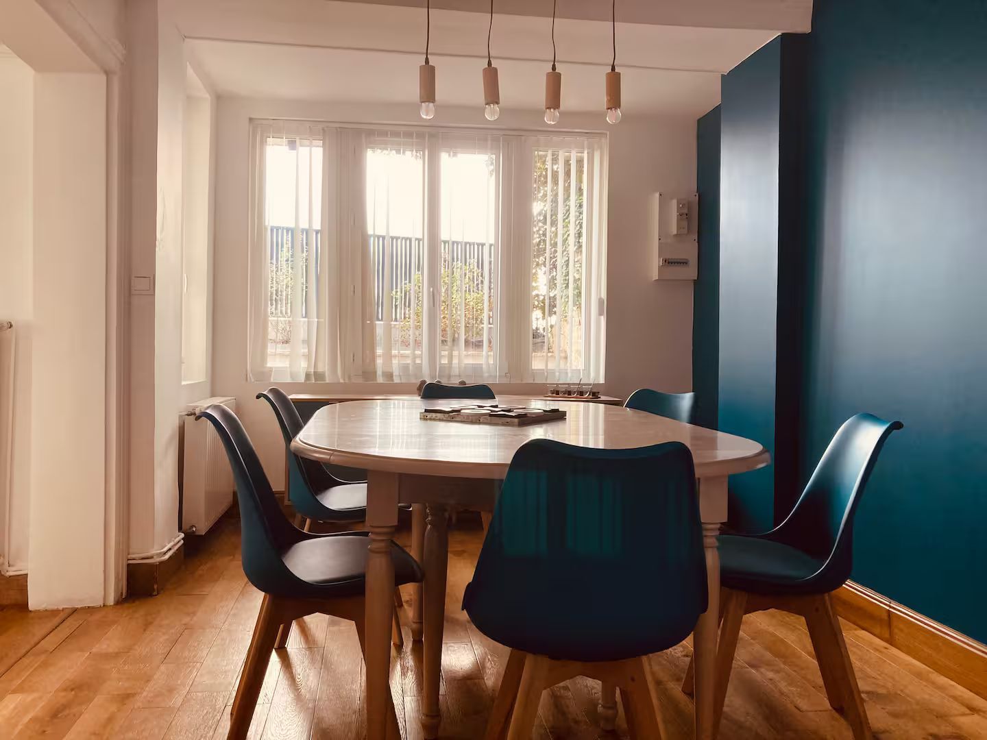 Une salle à manger avec une table et des chaises et un mur bleu.