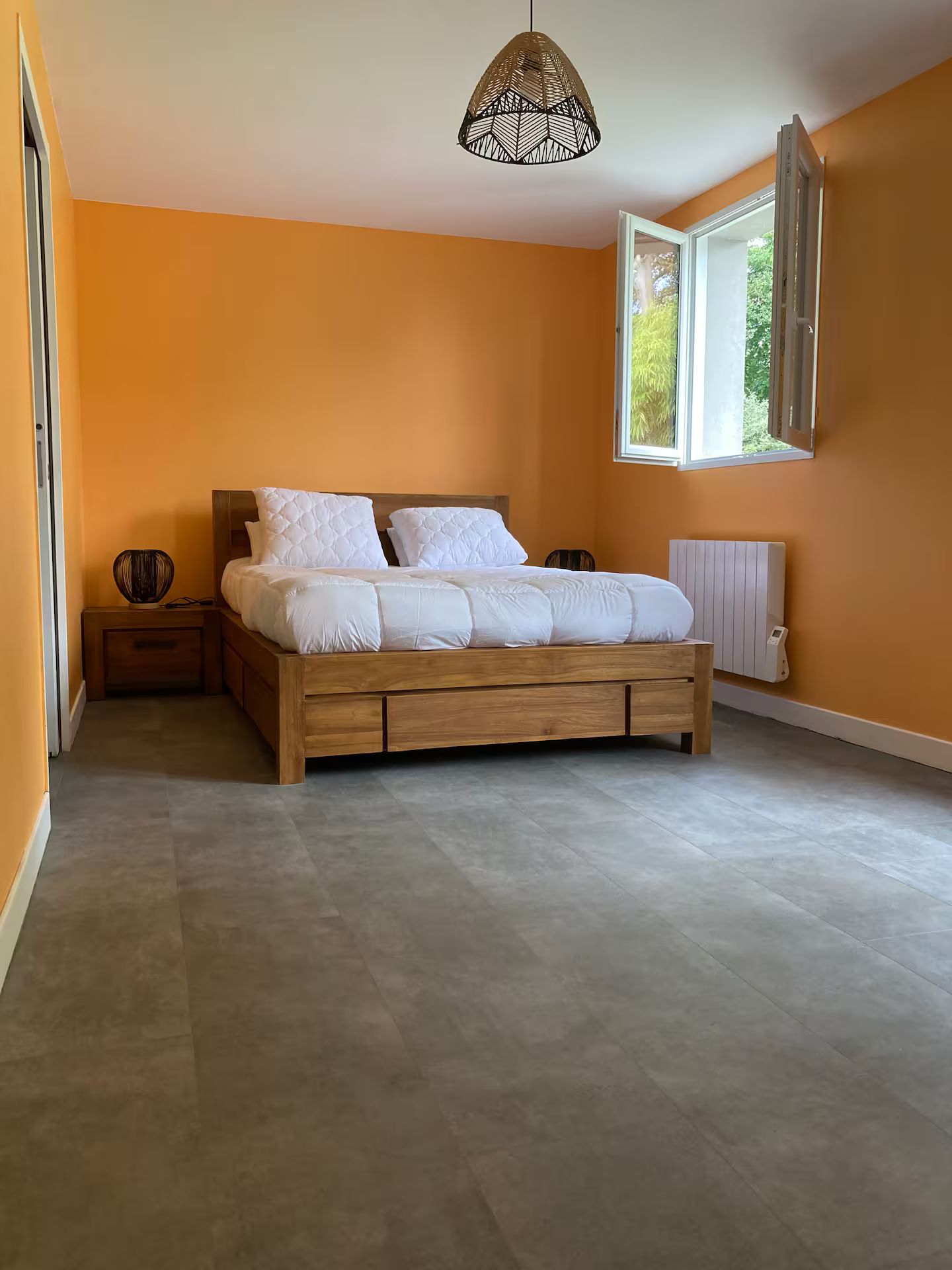 Une chambre aux murs orange et un lit en bois.