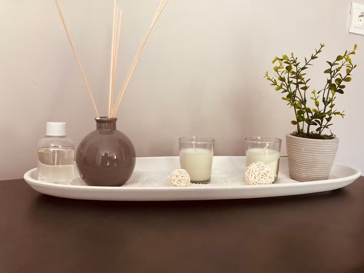 Un plateau avec des bougies, un vase et une plante dessus