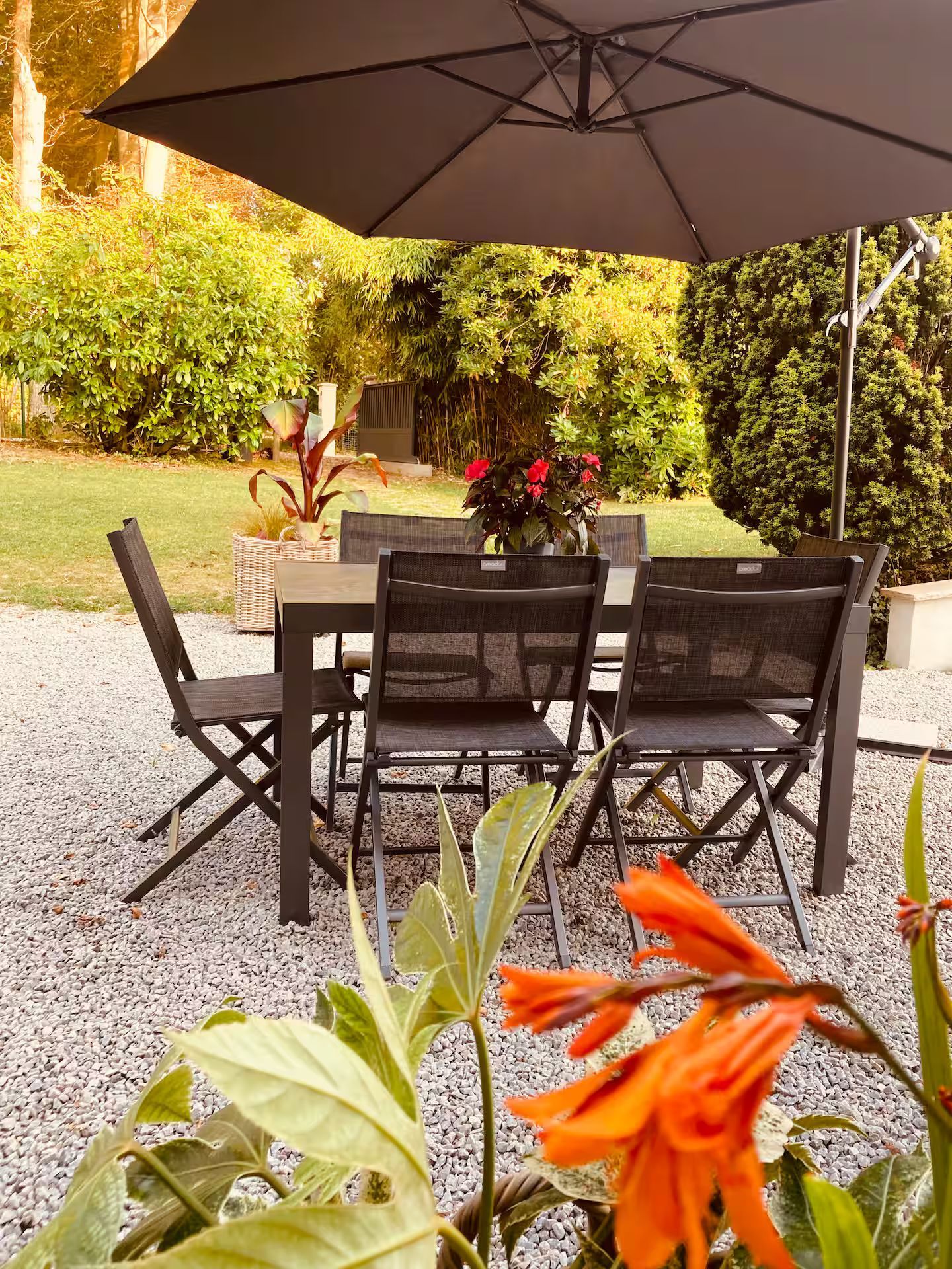 Un patio avec une table et des chaises sous un parasol