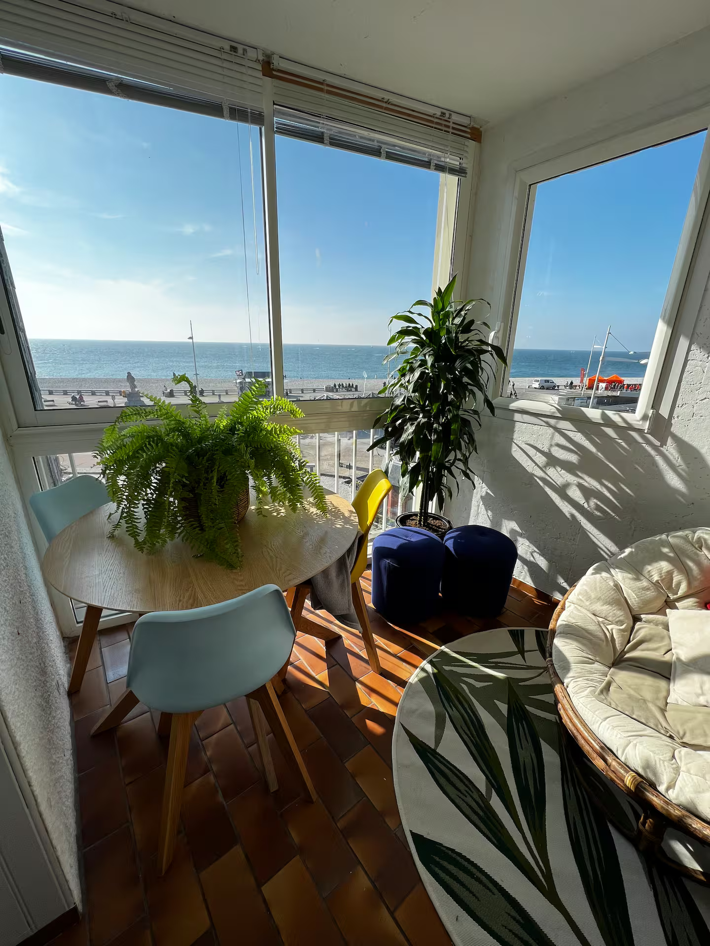 Un salon avec une table et des chaises et une vue sur l'océan.