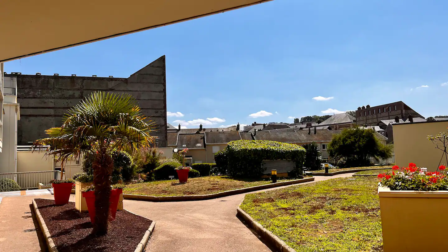 Un jardin verdoyant avec un bâtiment en arrière-plan