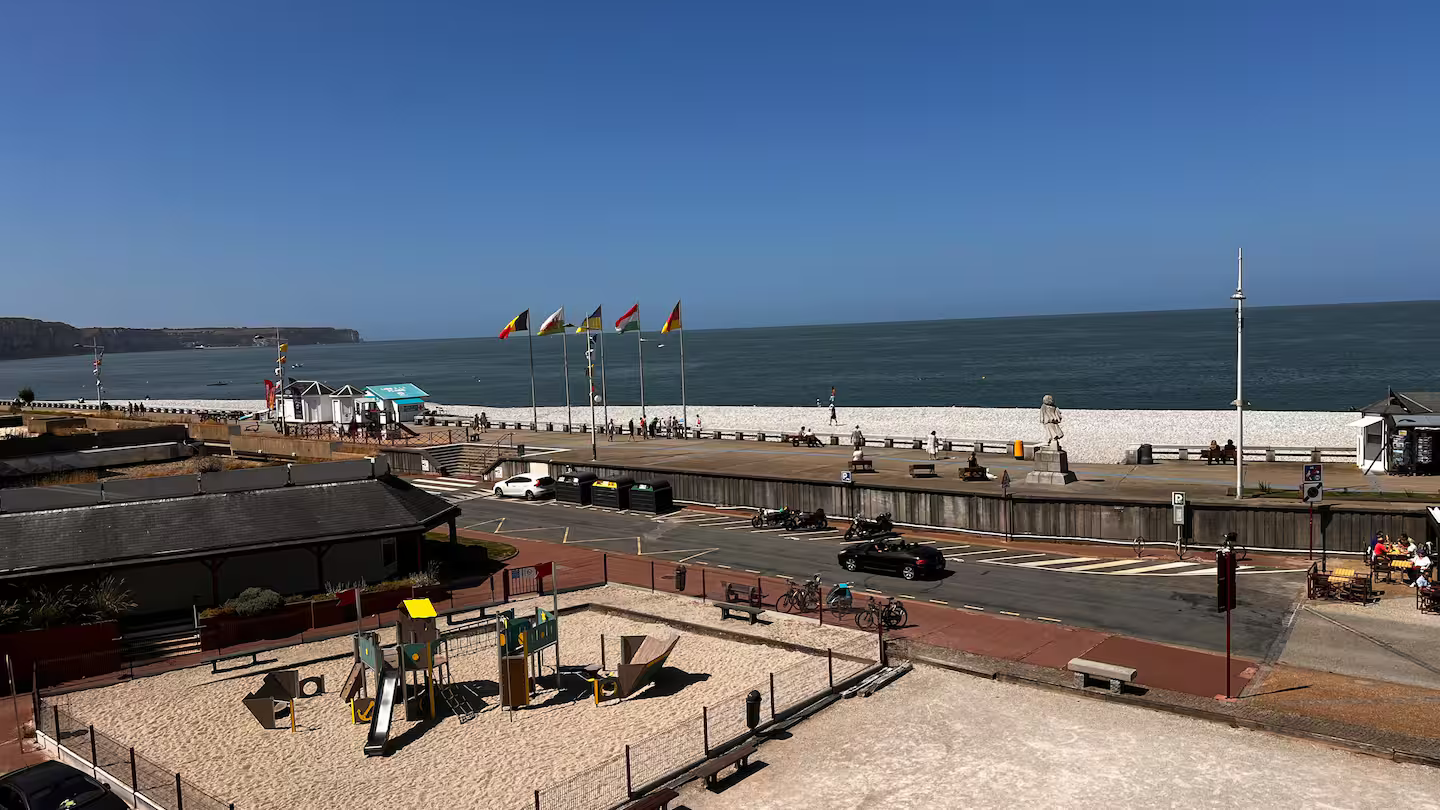 Une vue aérienne d'une plage avec une aire de jeux au premier plan et l'océan en arrière-plan.