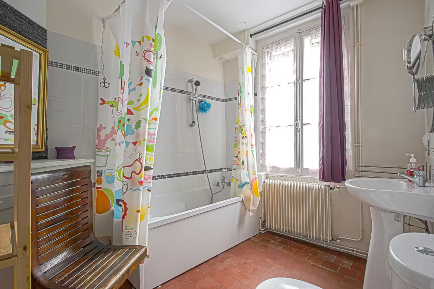 Une salle de bain avec baignoire, lavabo, WC et miroir.