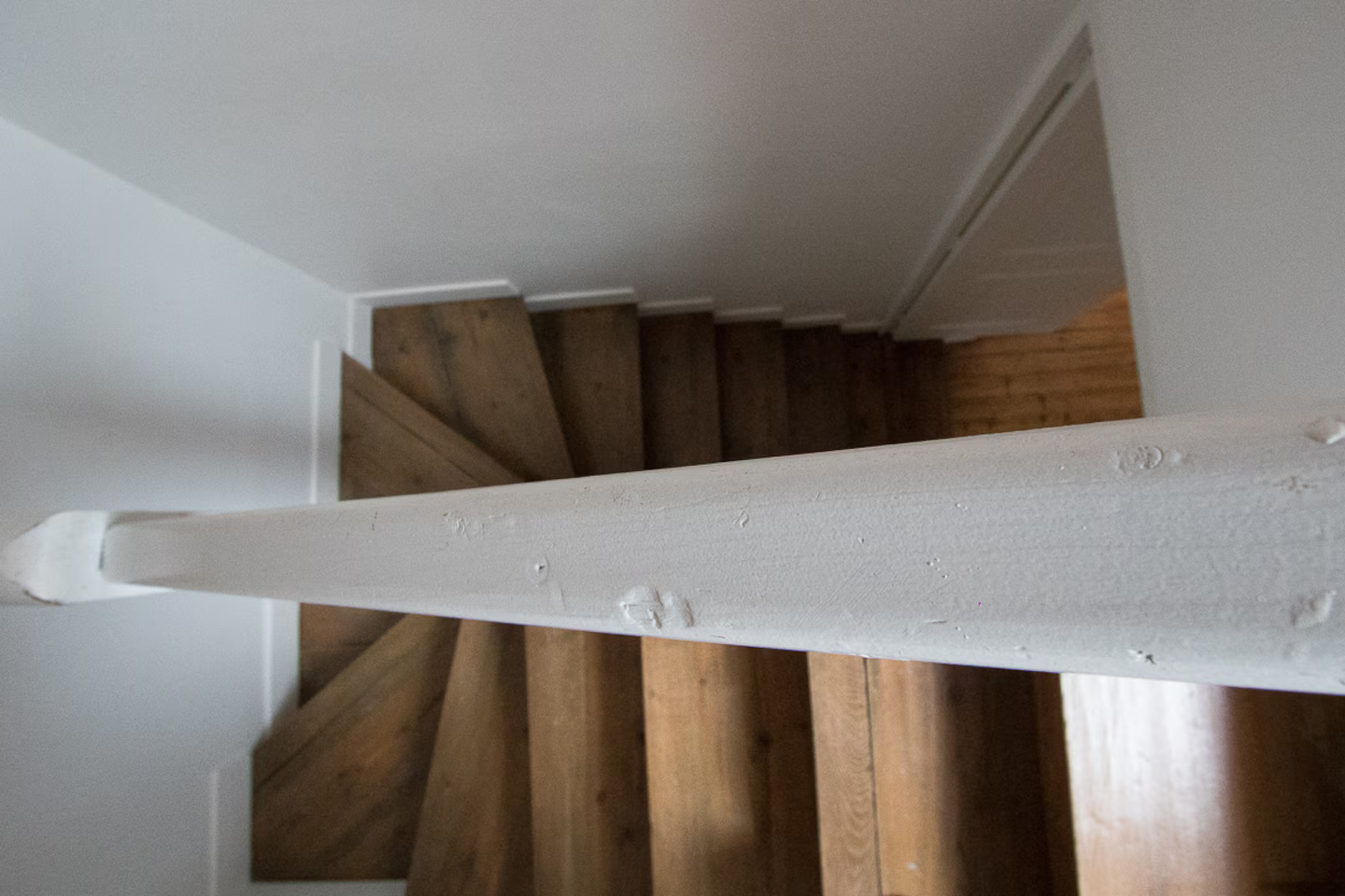 Un escalier avec des marches en bois et une rampe blanche