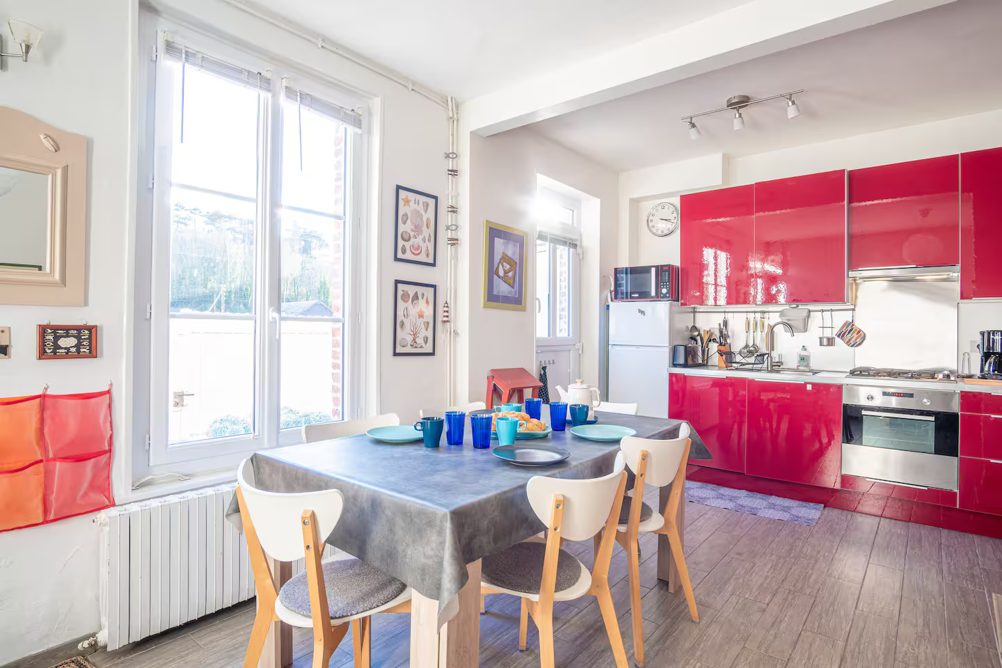Une cuisine avec des armoires rouges et une table et des chaises.